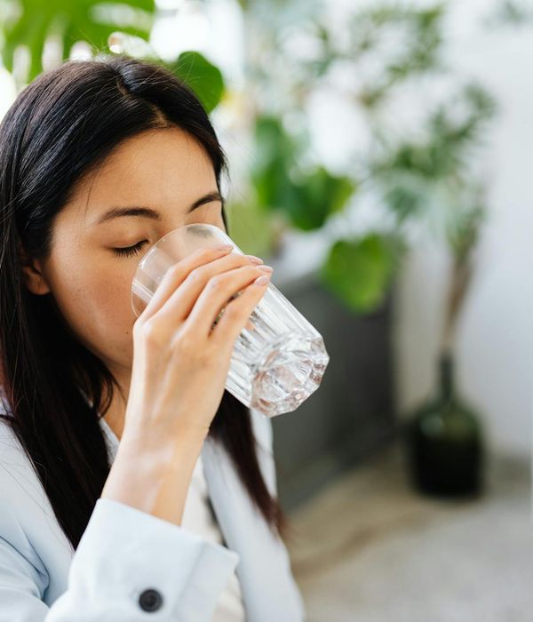 Woman stretching calmly in a bright office environment during her break.